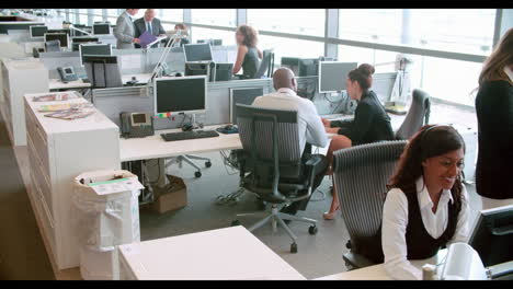 un gerente sénior dirigiéndose a los trabajadores en una oficina de plan abierto