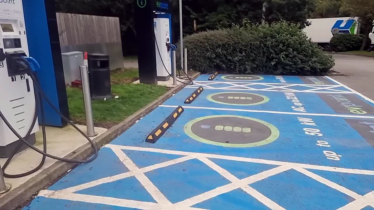 Electric vehicle power charging station point with asphalt marking signs on the ground