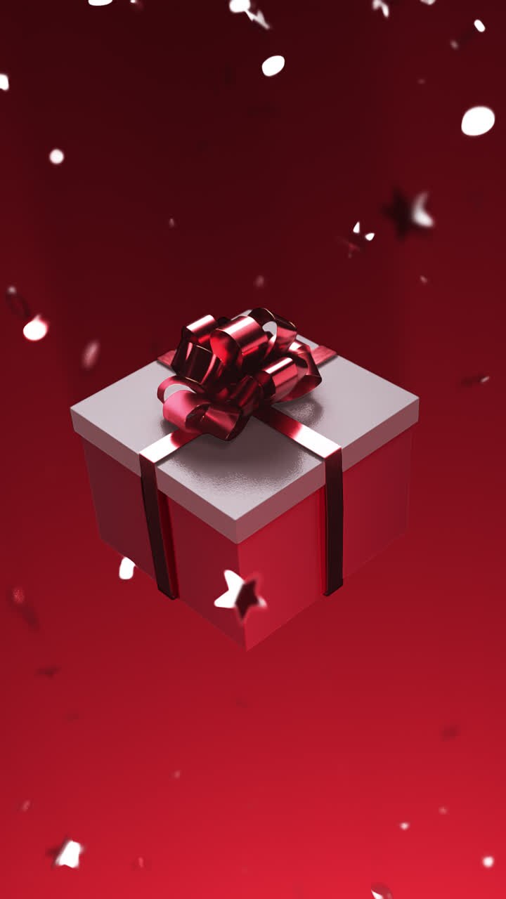 A gift with a red bow is spinning on a red background with falling confetti