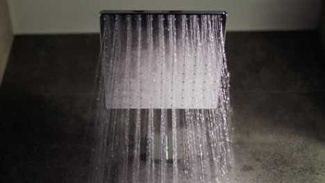 Wasserstrahlen-Fließen-Aus-Dem-Quadratischen-Duschkopf,-Zeitlupenvideo