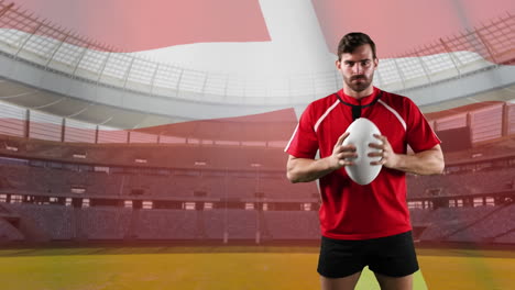 professional rugby player standing in front of a flag and stadium