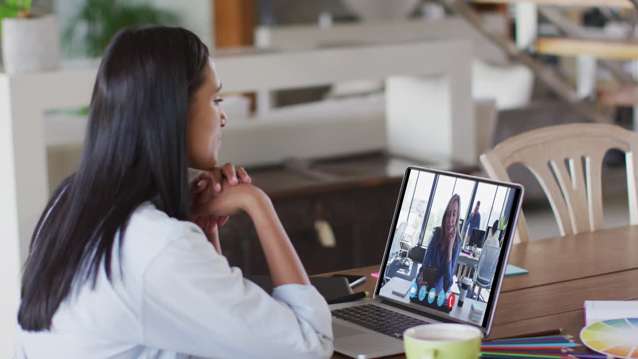 Caucasian woman using laptop on video call with female colleague working from home