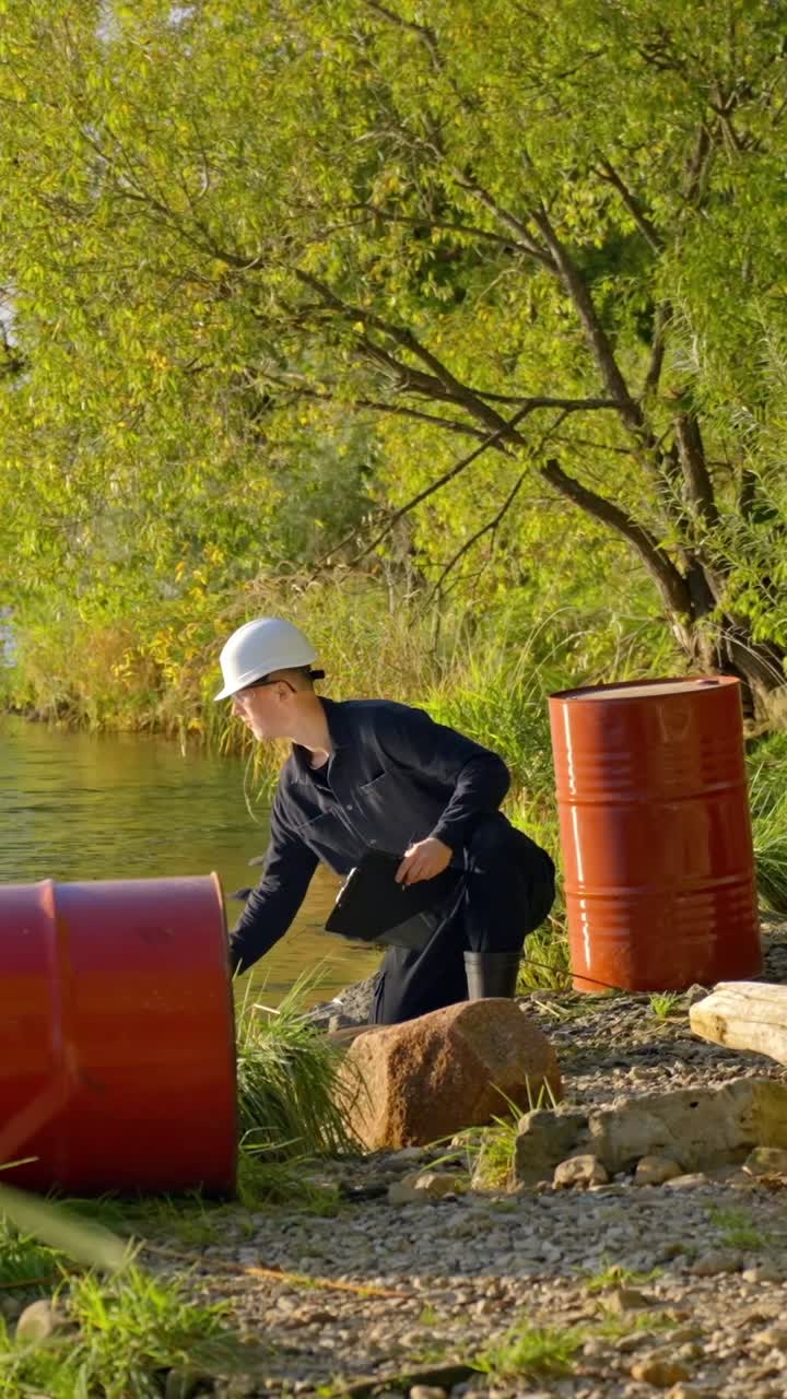 Worker tests water by barrels in nature, highlighting pollution issues, vertical