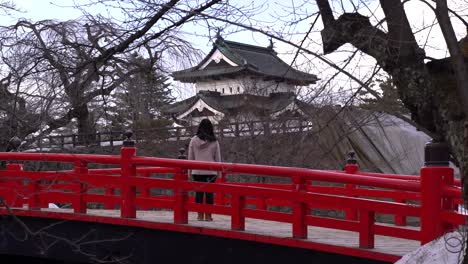 Stunning-scenery-in-Northern-Japan-with-female-tourist-looking-out-towards-Hirosaki-Castle