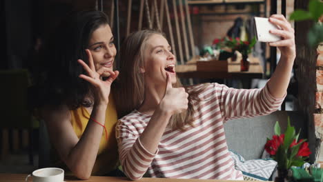 happy friends taking selfie in a cafe