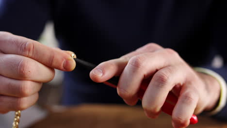 close-up of hands using pliers for jewelry making