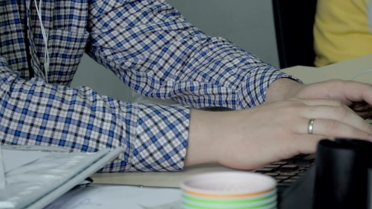 joven escucha música y escribe en el teclado en la oficina