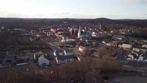 Drone-circling-the-central-church-in-the-town-of-Hudson,-Massachusetts-on-the-Assabet-River-during-winter