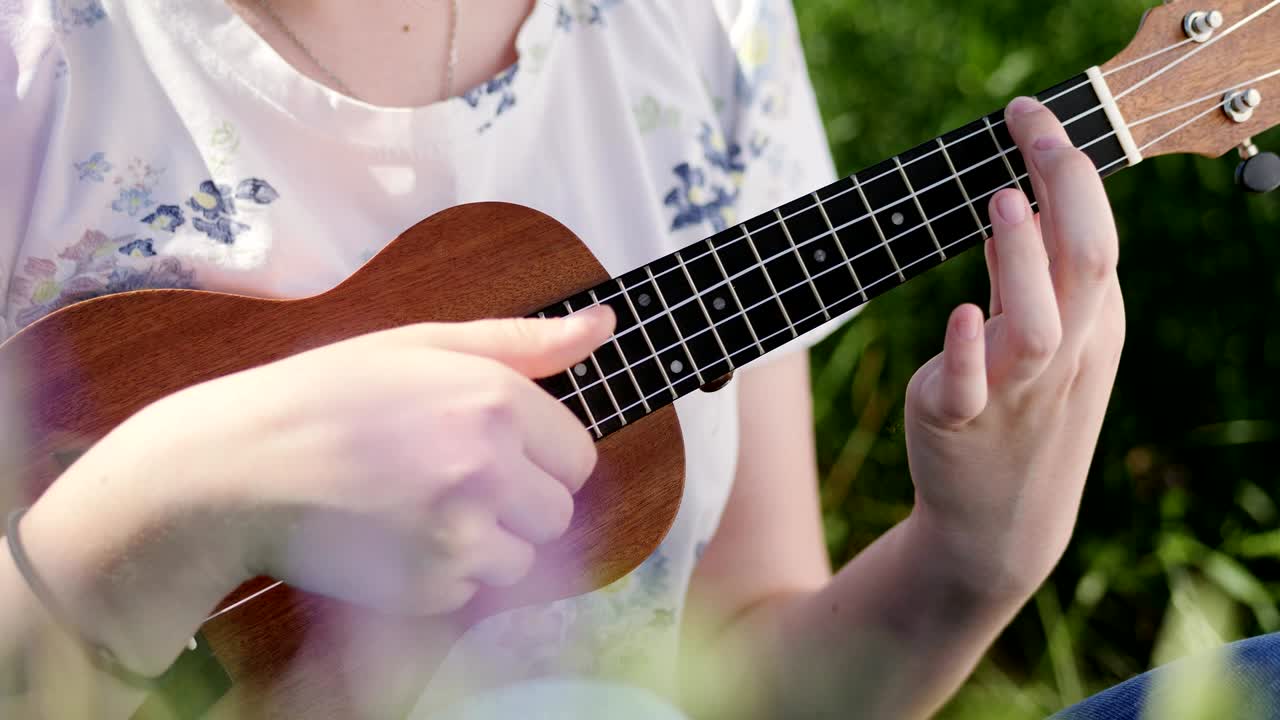 una joven hermosa tocando el ukulele.