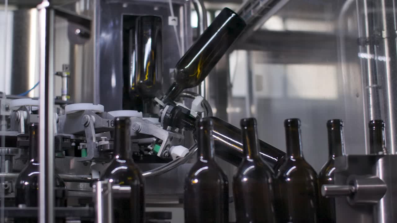 botellas de vidrio vacías en maquinaria en la línea de producción de la fábrica