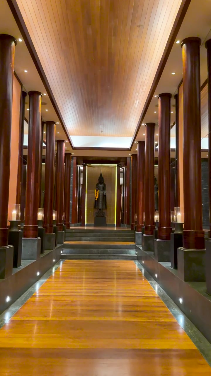 Elegant gang med Buddha-statue og træsøjler
