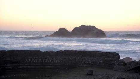 Tides approaching the shore and crashing on rocks
