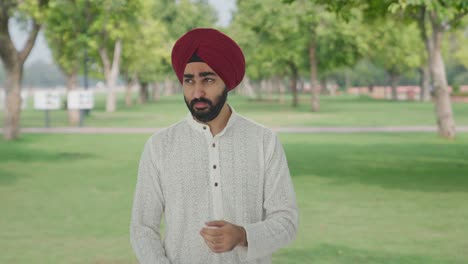 sick sikh indian man suffering from fever in park