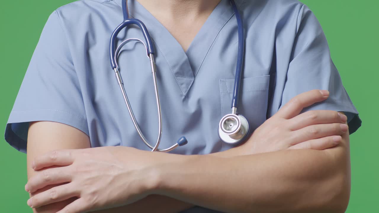 Close Up Of Male Doctor With Stethoscope Crossing His Arms On Green Screen Background In The Hospital