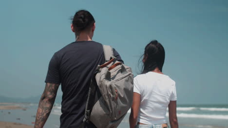 Una pareja caminando por la playa.