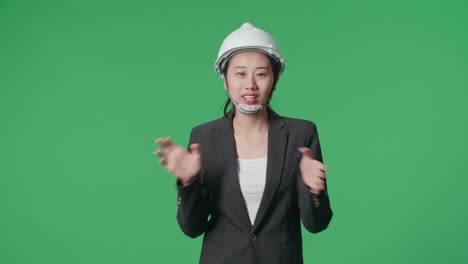 smiling asian female engineer talking while walking in the green screen studio