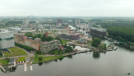 paisaje urbano de la ciudad de amsterdam entre una exuberante vegetación con vistas a la estación de tránsito amsterdam amstel y al puente amstelstroom cerca del río amstel, holanda del norte, países bajos