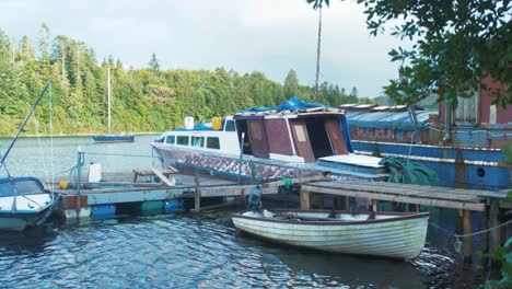 Old-boats-tied-to-dock-while-being-repaired-and-painted,-wide-shot