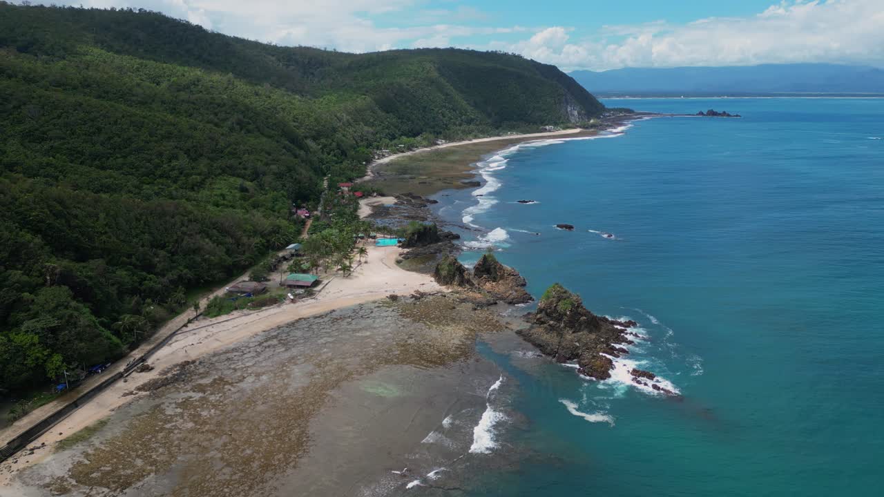 A breathtaking wide drone shot showcases the endless shoreline, where golden sands meet the rolling waves under a vast, open sky.