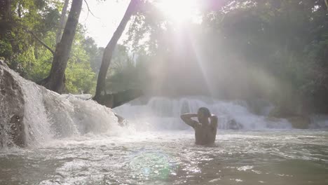 man relaxing with waterfall in tropical nature, slow motion