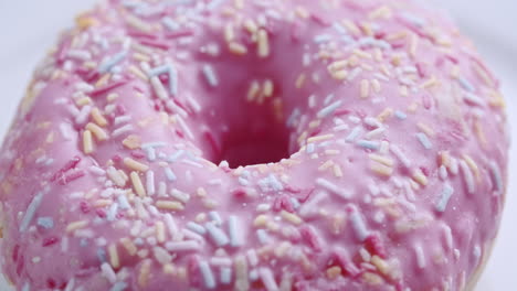 close up shot of a pink donut spinning on a white surface