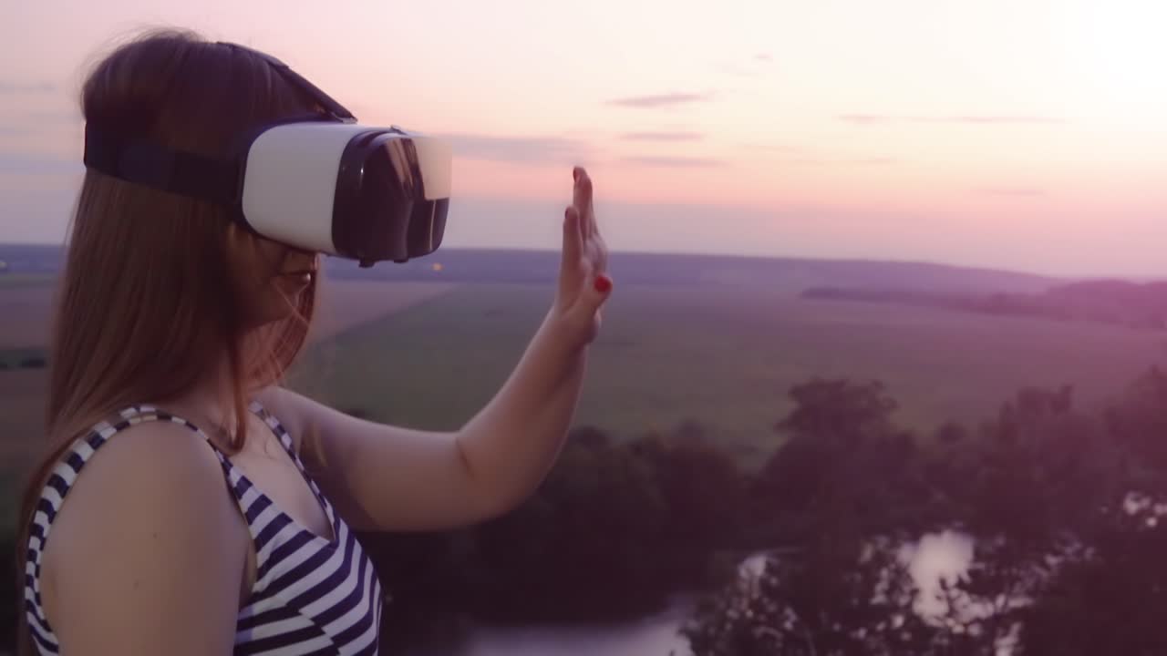 mujer experimentando la realidad virtual al atardecer