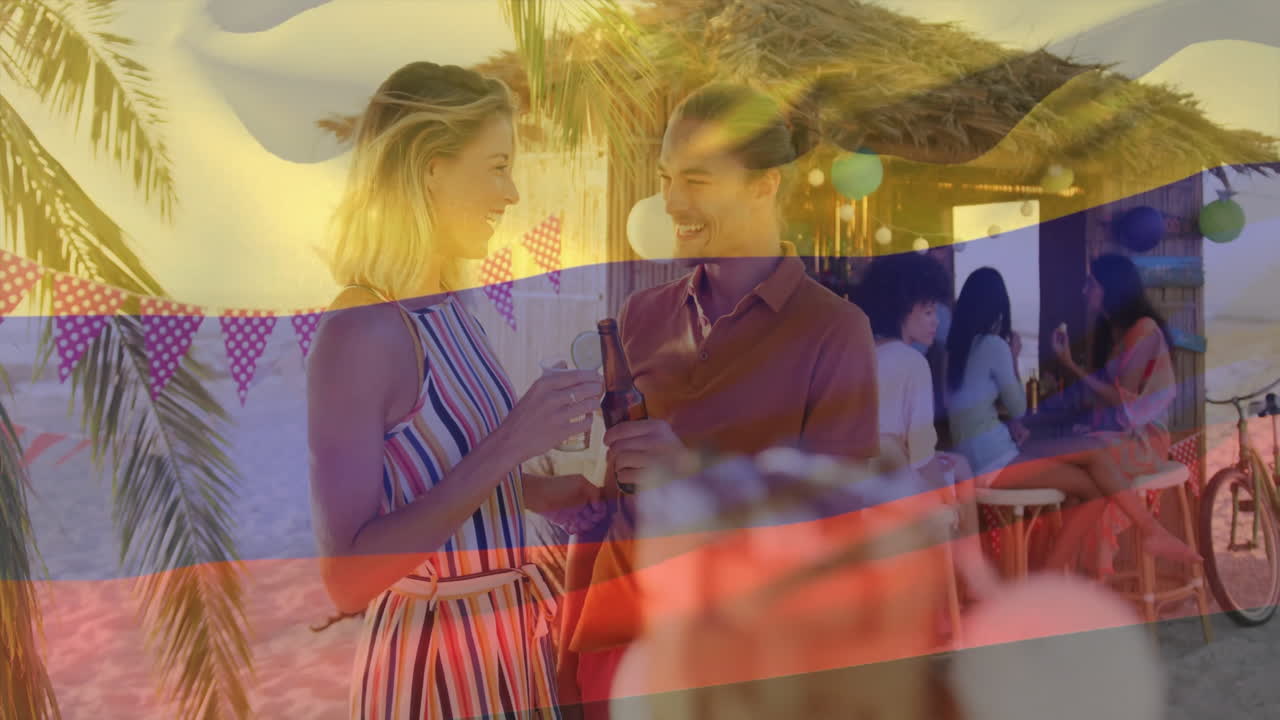 At beach party, couple sipping drinks with colorful flag animation overlay