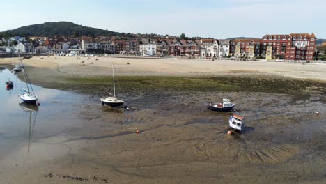 vista aérea de los barcos en la marea baja brillante soleado cálido rhos en el mar junto al mar playa de arena marina promenade órbita rápida a la derecha