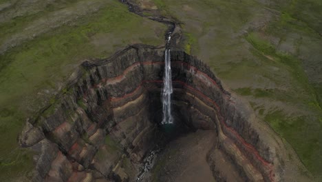 Toma-Aérea-De-Arriba-Hacia-Abajo-De-La-Famosa-Cascada-Hengifoss-Y-El-Impresionante-Barranco-En-Islandia-Durante-El-Día