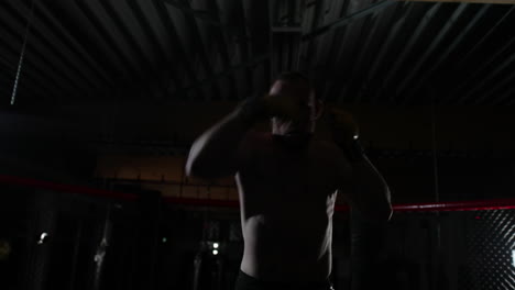 카메라 앞에서 강렬하게 새장에서 스파링하는 mma 전투기 훈련의 중간 샷