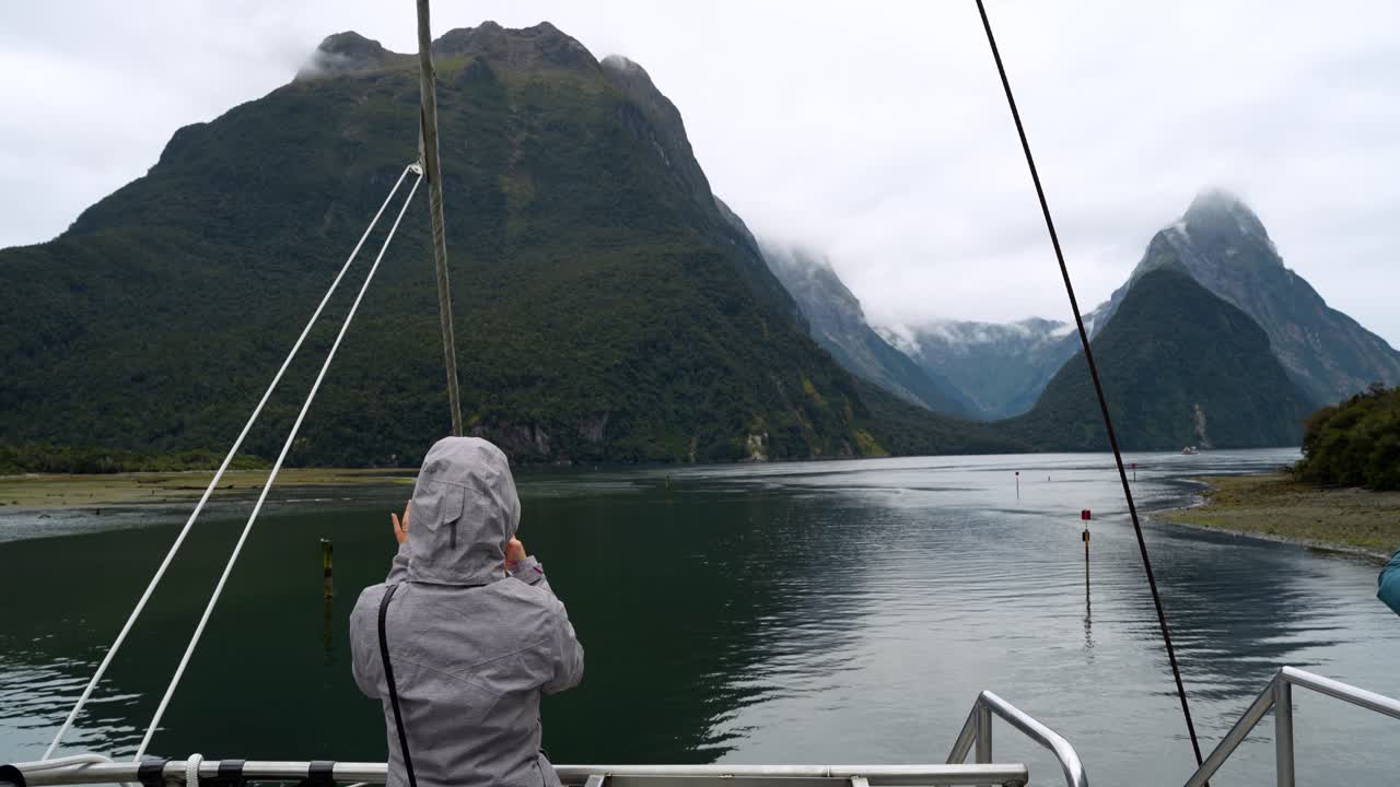 Person on a boat looking out at a majestic mountainous fjord