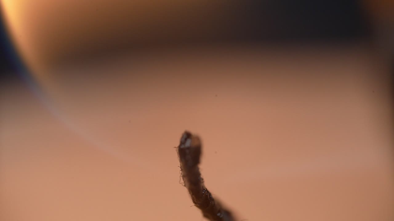A flickering candle wick glowing in close-up view, symbolizing warmth and solitude