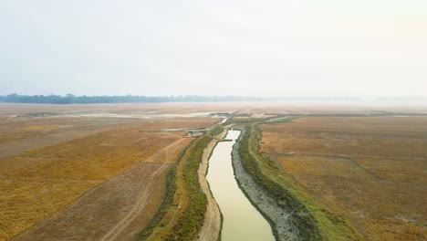 a breathtaking view captured by an aerial drone flying away from a river located in a rural area