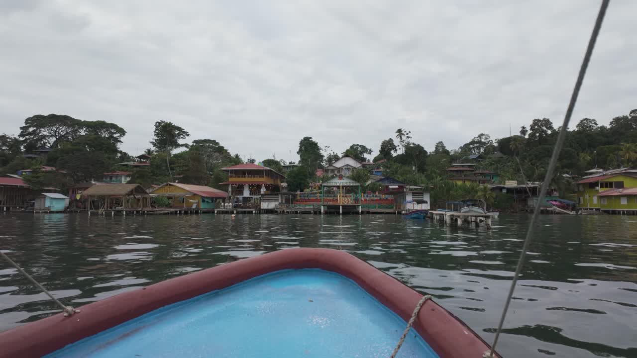 barco que se acerca a las coloridas casas frente al mar en la isla de bastimentos, bocas del toro, panamá