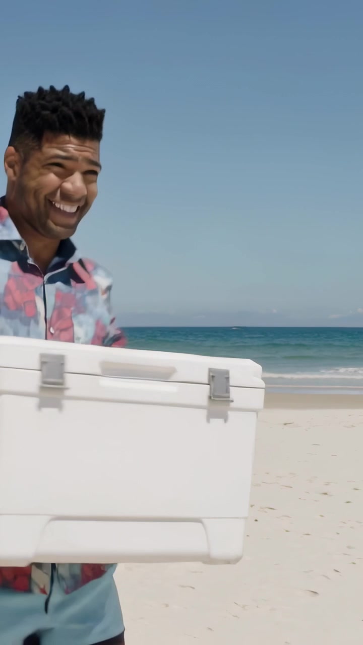 Vertical video: Entering left man in shirt toting cooler on beach eyeing kid following, copy space