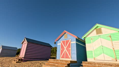 vibrant beach huts under a clear blue sky