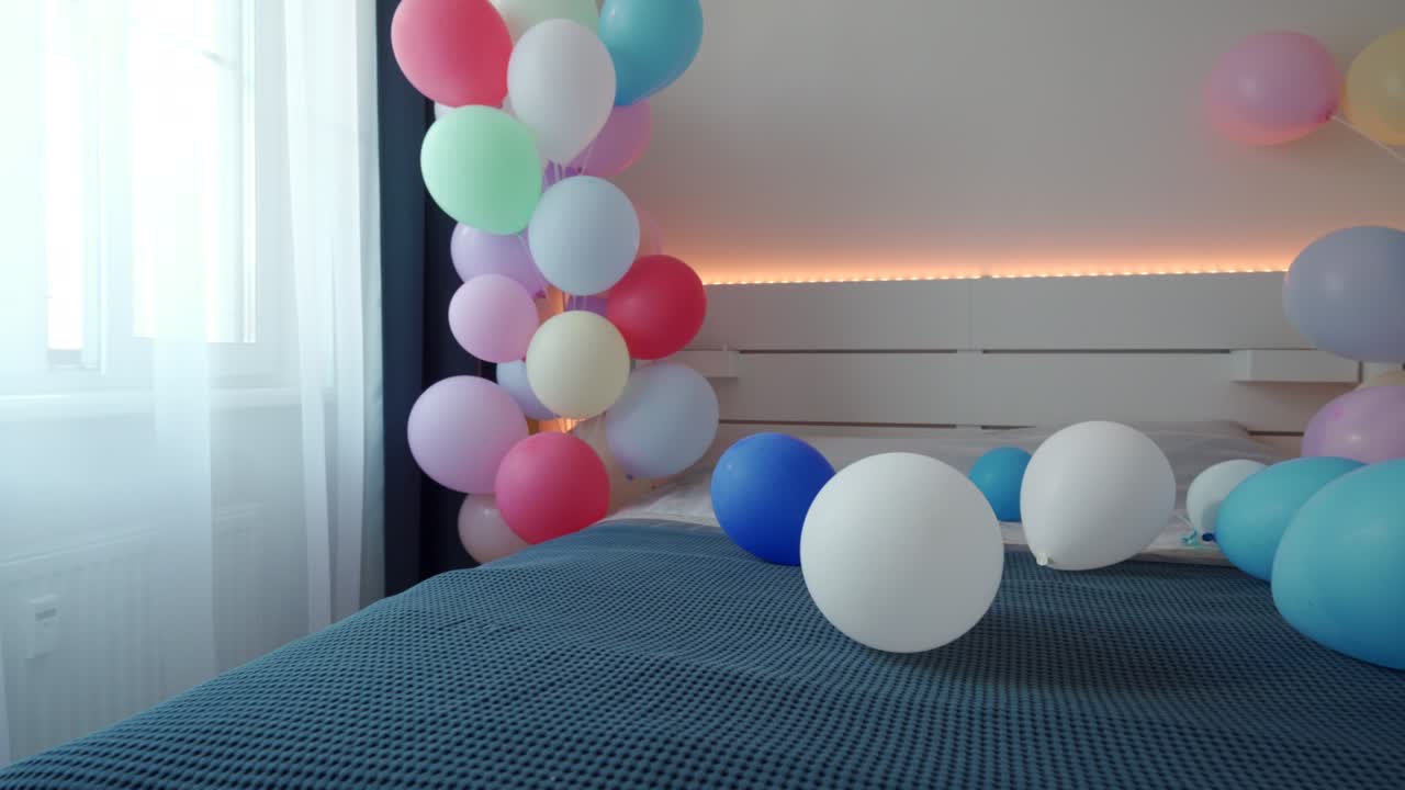 cama en el dormitorio decorada con globos de colores, interior del dormitorio del apartamento. fecha romántica y fondo de vacaciones.