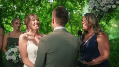 slow motion bride laughing, holding hands with groom at wedding ceremony altar