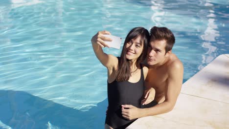 Hübsches-Paar-Macht-Foto,-Während-Es-Im-Pool-Steht