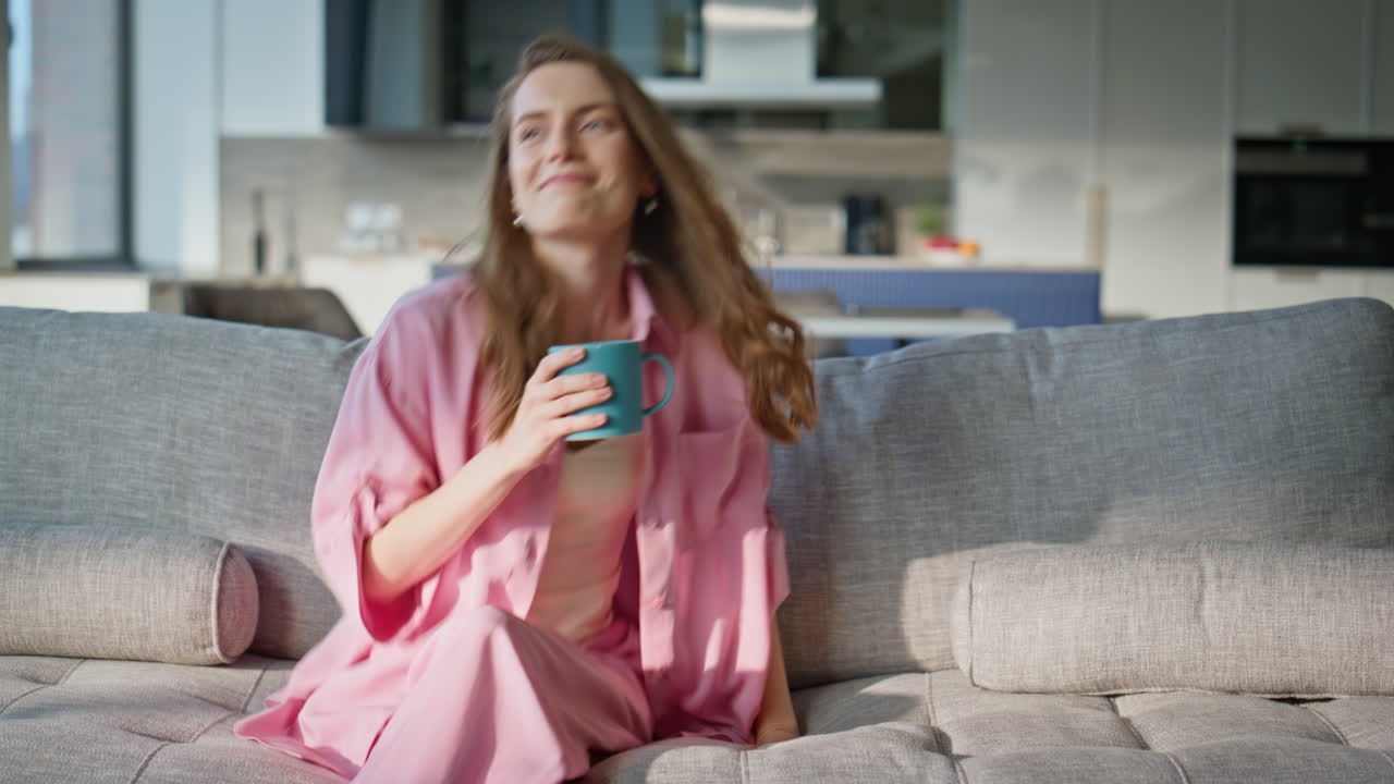 Loving boyfriend giving coffee cup to smiling woman at home couch. Happy spouses