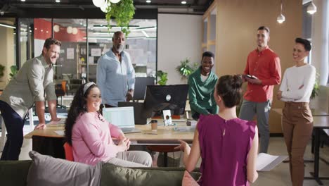 Happy-diverse-business-people-discussing-work-during-meeting-at-office