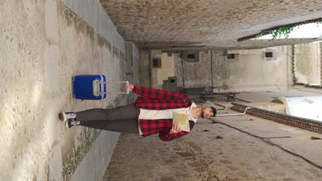 traveling man with suitcase checking map