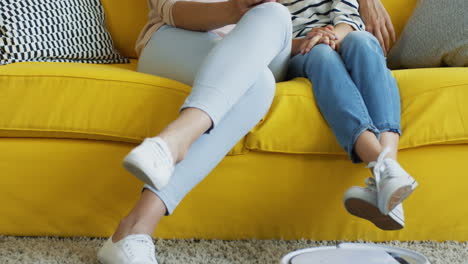 mini vacuum cleaner cleaning the carpet while mother and daughter hugging on the sofa