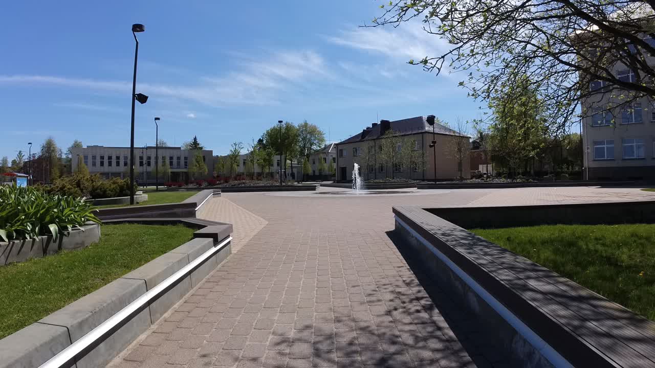Танцующий фонтан на городской площади в солнечный день.