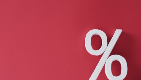 video of white percent sign with copy space against red background