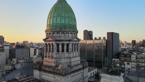 órbita-Aérea-Del-Palacio-De-Congresos-Argentino-Cúpula-De-Bronce-Verde-Y-Monumento-Quadriga-Al-Atardecer,-Buenos-Aires