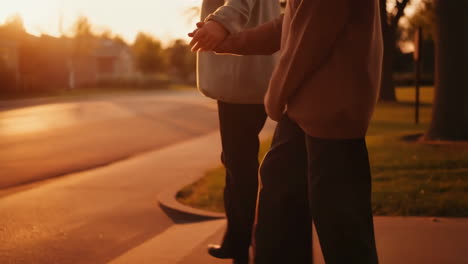 people walking on a sidewalk at sunset