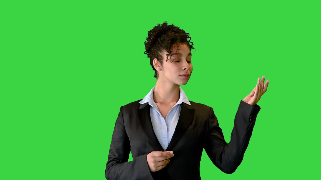 dama afroamericana en un traje señalando espacios en blanco en una pantalla verde, llave de croma