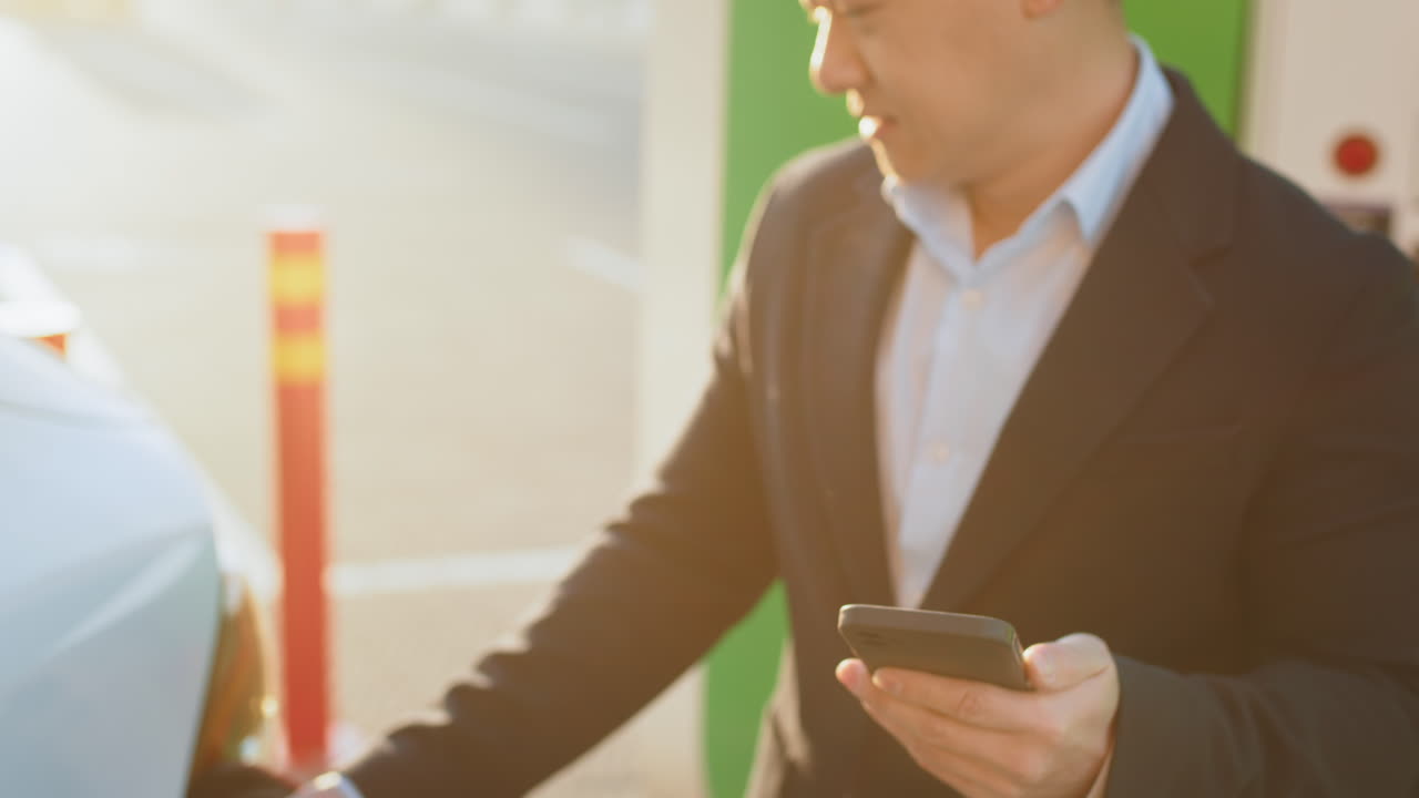 전기차를 충전하는 사업가