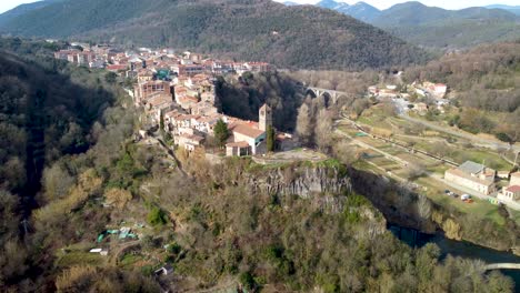 Aerial-Drone-View-of-Castellfollit-de-la-Roca:-The-Cliffside-Town-in-Girona’s-Pyrenees,-Near-Garrotxa-Volcanic-Zone